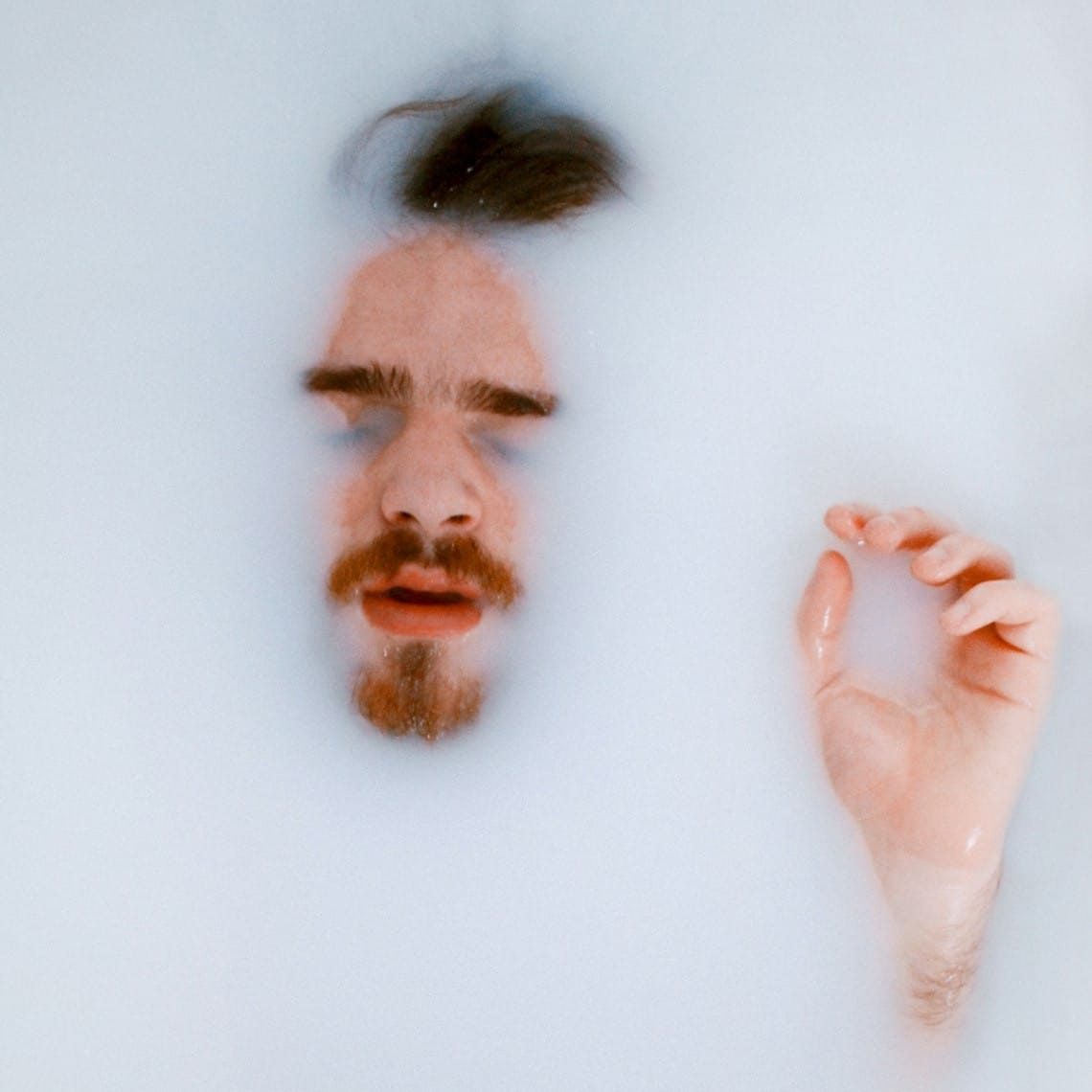 Fotka muže ležícího v mléce ilustrující téma předčasné ejakulace na webu Hledání sexuálního grálu